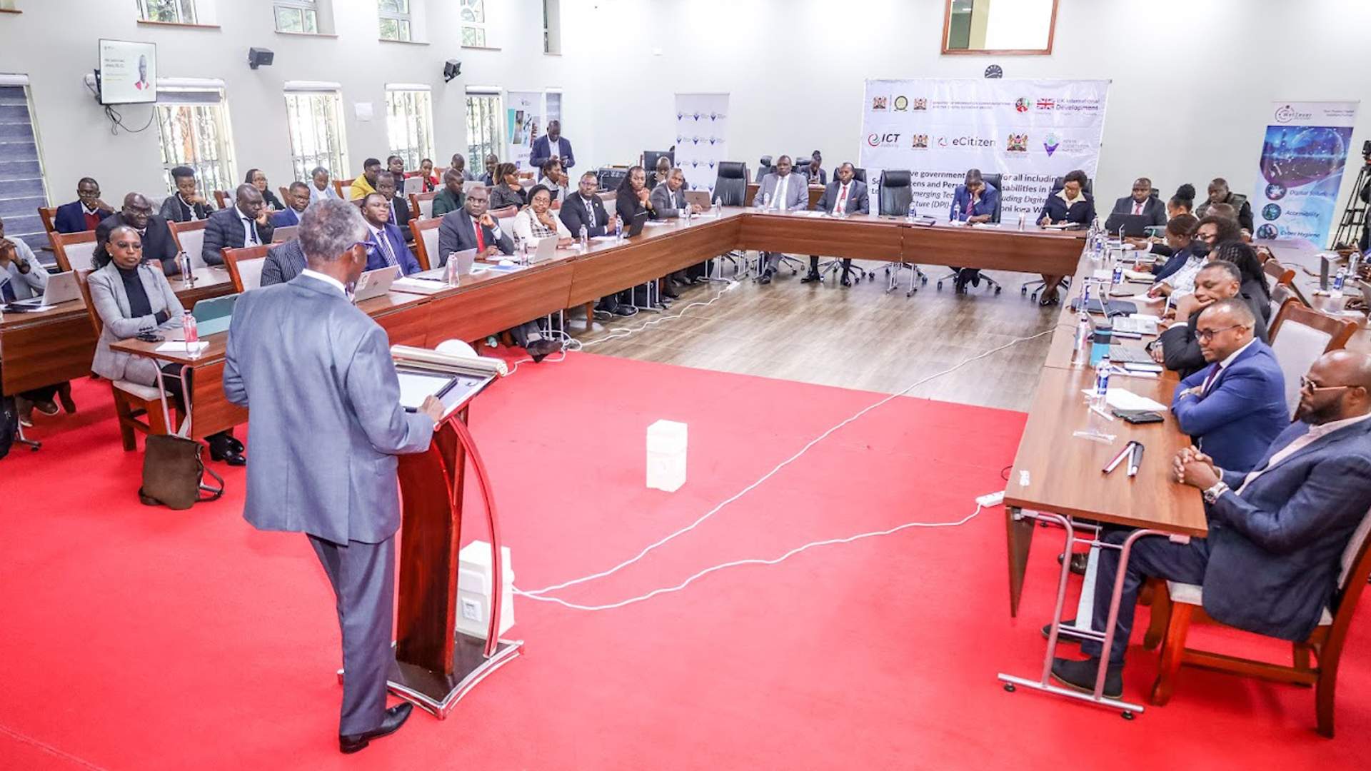 Justice Isaac Lenaola addresses workshop attendees at the Justice Sector Digital Inclusivity workshop, held at the Prosecution Institute in Loresho, Nairobi, in August 2025, with participants seated around long tables.